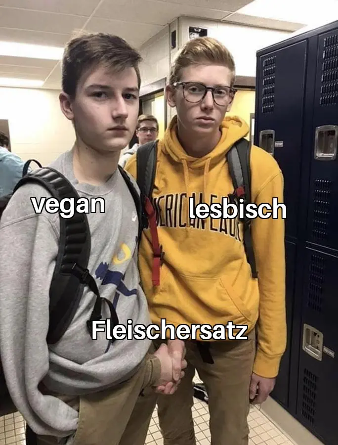 Zwei Leute (vegan & lesbisch), die sich verdeckt die Hand geben (Fleischersatz)