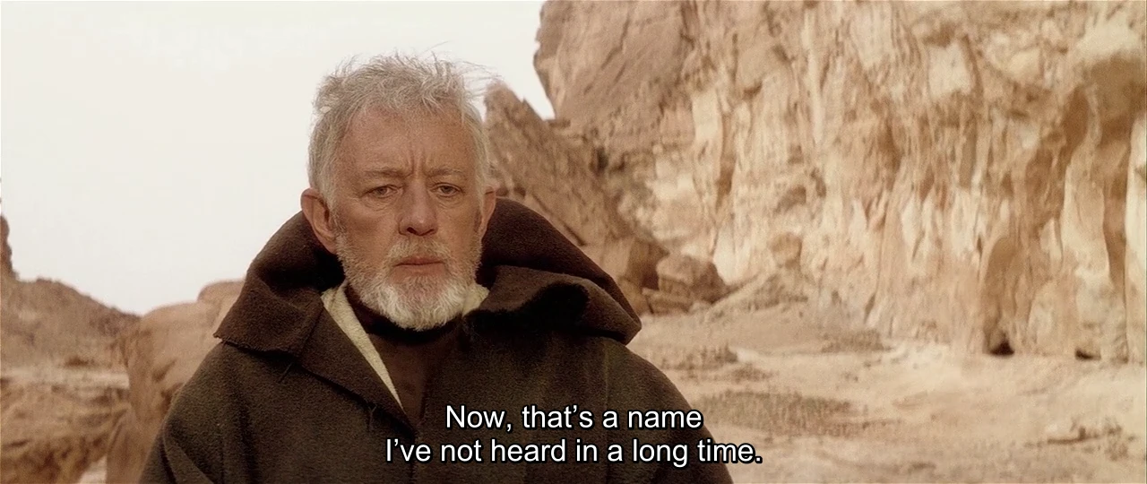 It is Alec Guinness playing Obi Wan Kenobi from Star Wars IV: A New Hope saying "Now, that's a name I've not heard in a long time." He is in the desert of Tatooine surrounded by pale cliffs and sand etc.