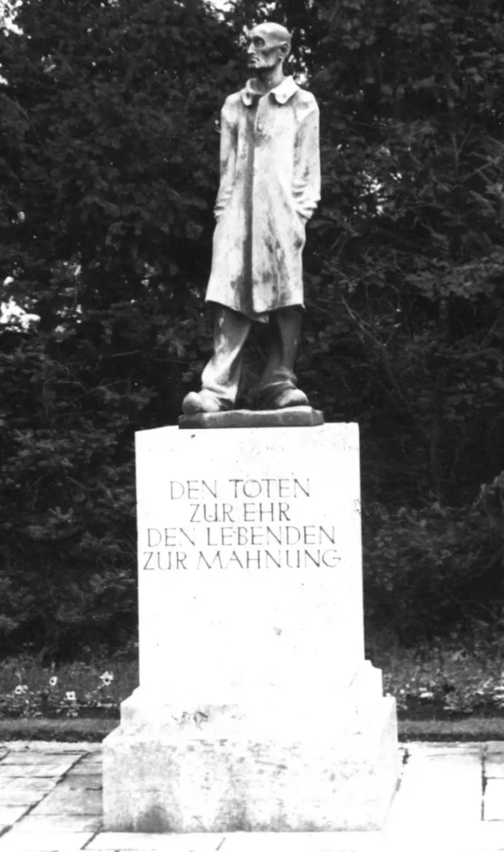 a statue of the unknown inmate in Dachau which reads: In honor of the dead, and a reminder to the living. 