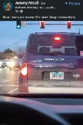 A rear view of a dark blue SUV with a license plate that reads "QRSTUV". On the back of the car, decals spell out parts of the alphabet: "ELEMEN OP" on the left, "ABCDEFGH IJK" above the license plate, and "WXYZ" on the right. The car is stopped at a traffic light, which shows a green signal for straight ahead but a red arrow for a left turn. The image is a screenshot from a LinkedIn post by Jeremy Nicoll. The post caption reads, "Now here's someone who sees deep connections."