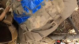 Ukrainian soldier shows the helmet that saved him from shrapnel during artillery shelling near Klishchiivka