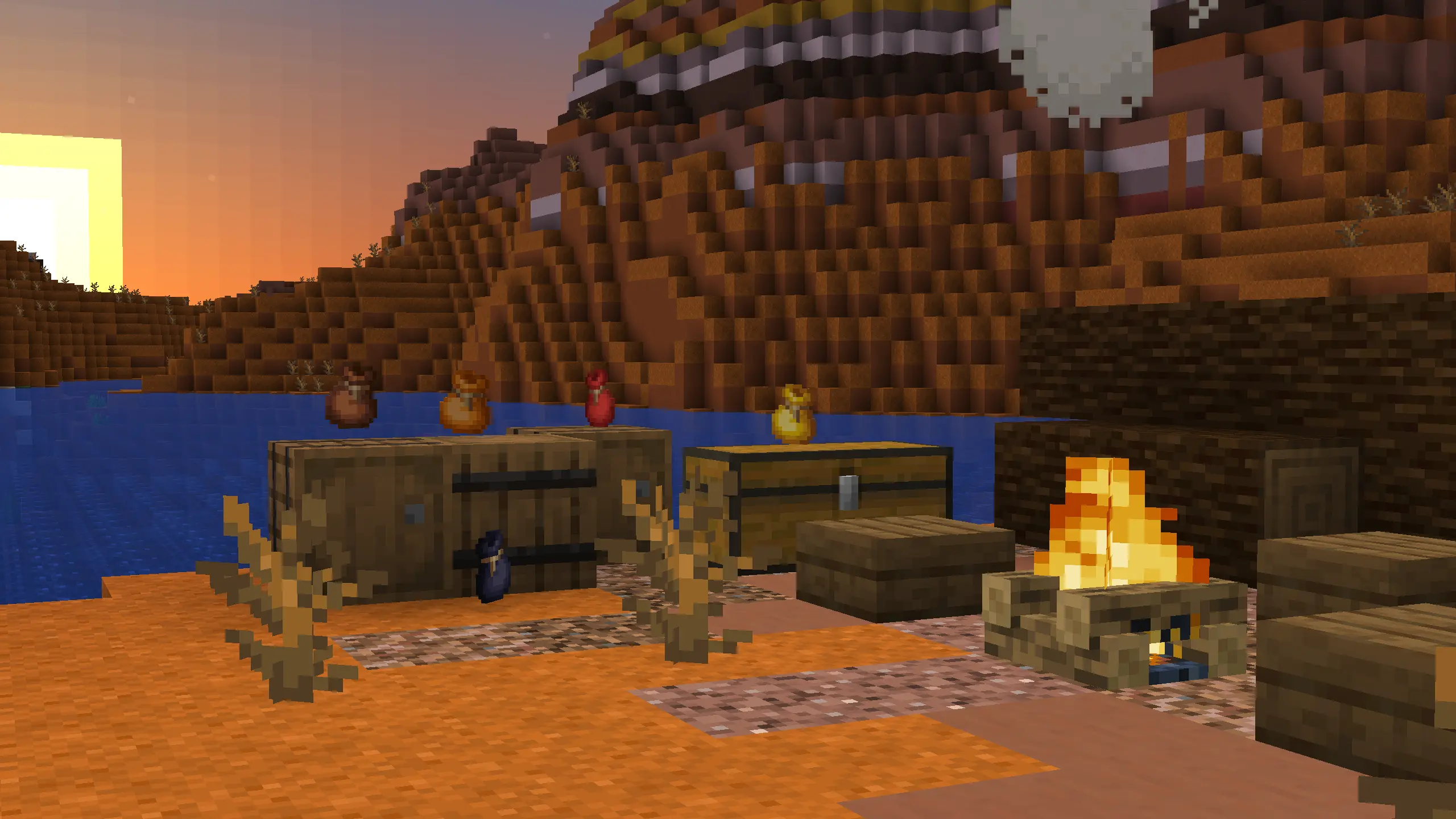 A campfire in a badlands biome, with some storage containers, on which there are some bundles.